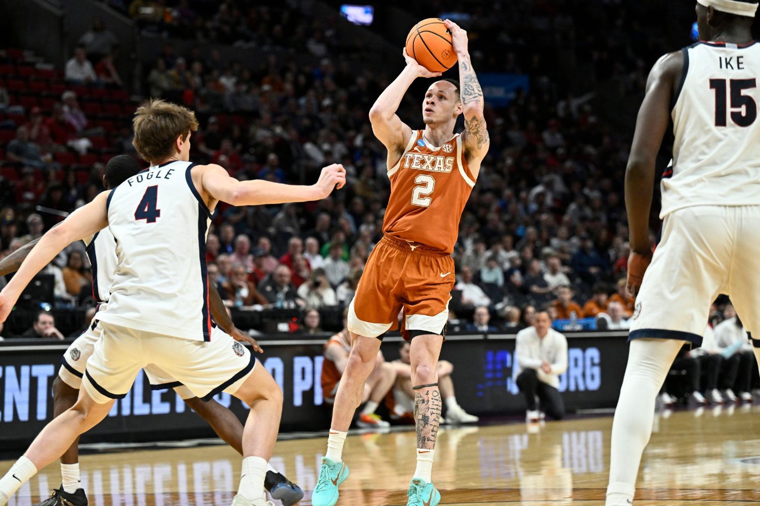 Mar 21, 2026; Portland, OR, USA; Texas Longhorns guard Chendall Weaver (2) shoots against Gonzaga Bulldogs guard Davis Fogle (4) in the first half during a second round game of the men's 2026 NCAA Tournament at Moda Center