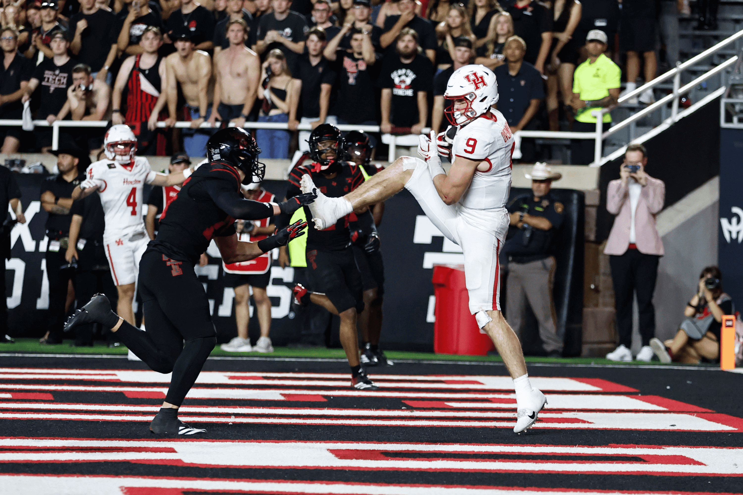 Sep 18, 2026; Lubbock, Texas, USA; Houston Cougars tight end Patrick Overmyer (9) catches a touchdown pass in front of Texas Tech Red Raiders defensive linebacker Austin Romaine (15) in the first half at Galaxy Stadium
