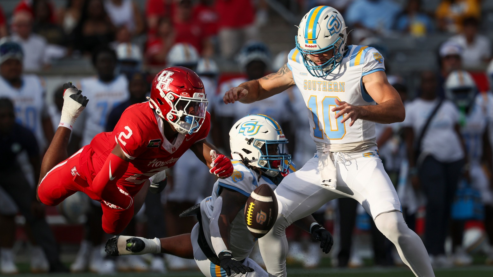 Sep 12, 2026; Houston, Texas, USA; Houston Cougars cornerback Jalen Mayo (2) strips the ball away from Southern University Jaguars quarterback Christian Johnson (10) during the first quarter at TDECU Stadium.